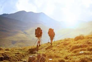 Two hikers going up a hill in afternoon sunlight, demonstrating the idea of behavioral customer acquisition data - by showing what potential customers like to do.