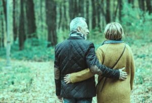 A couple walking arm-in-arm in the woods, demonstrating the importance of EAGLES (married, shared income) data in customer acquisition marketing.