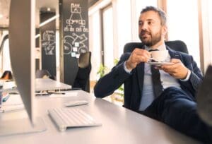 A man in a suit at his desk, demonstrating the idea of occupational customer acquisition data.